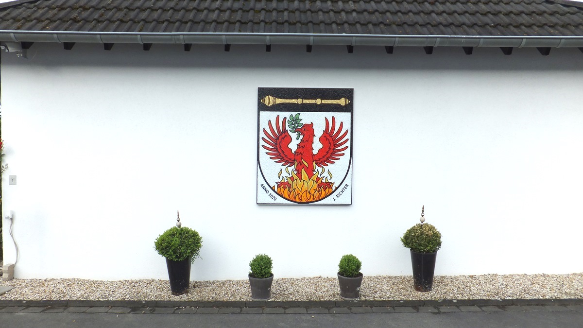 Wappen-Schild mit Richterstab und rotem Phönix. Diese symbolisieren die Familien beider Elternteile von Joachim Richter.